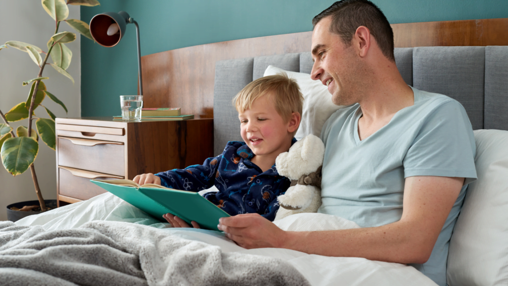 A diferença causada no comportamento infantil na vida de uma criança com a vida equilibrada, lendo com seu pai na cama.