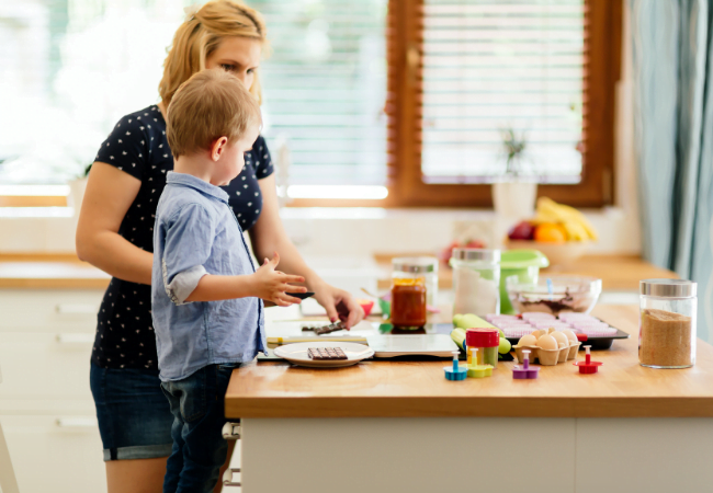 Criança ajudando a mãe na cozinha.