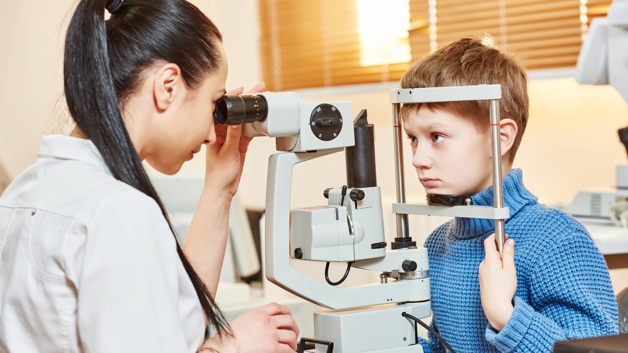 Garoto em consulta no oculista infantil.
