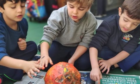 Crianças mexendo com tinta e papel mache na escola infantil AVIVA