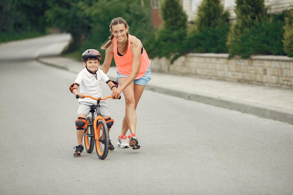 mãe ensinando filho a andar de bicicleta