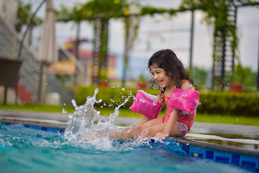 foto de uma criança na borda da piscina