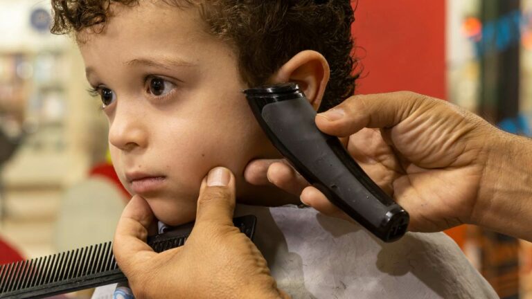 Garoto no cabeleireiro infantil cortando o cabelo.