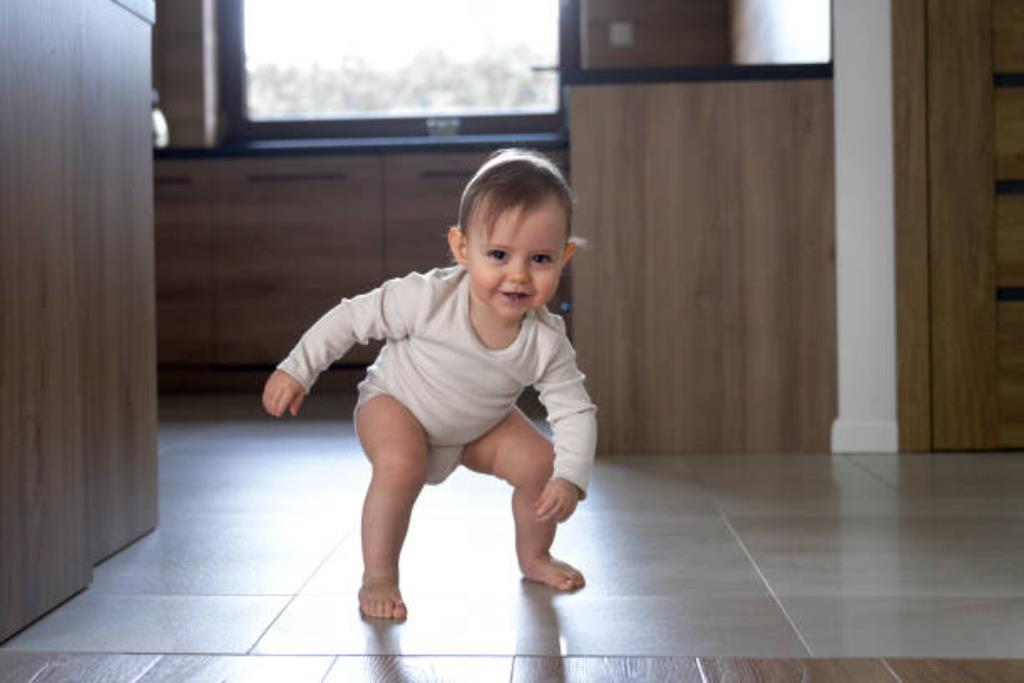 bebê levantando para ficar em pé e andar sozinho