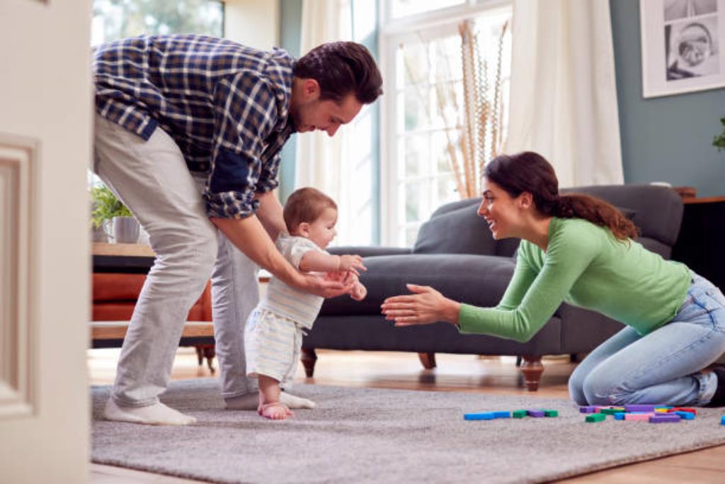 pai e mãe fazendo brincadeira para estimular o bebê a andar sozinho