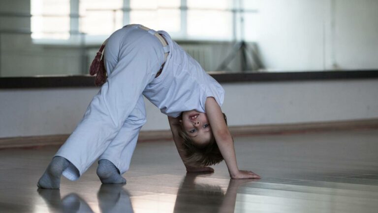 Garoto praticando capoeira infantil.