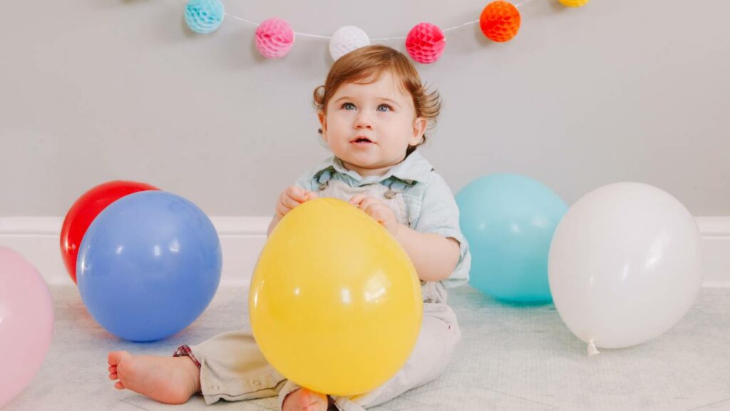 Bebê segurando balão.