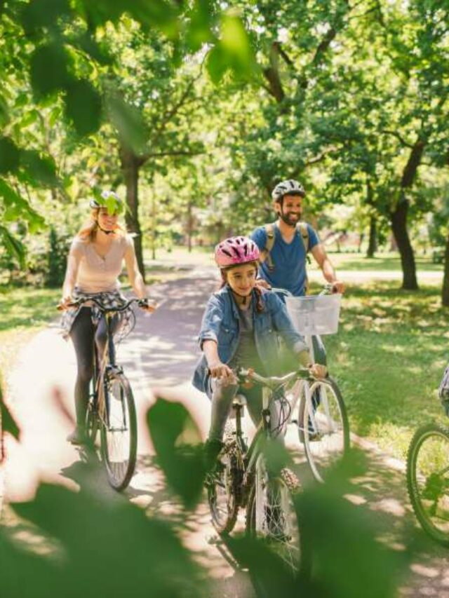Família passeando de bicicleta no parque.