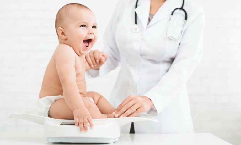 Bebê na balança do pediatra em perdizes.