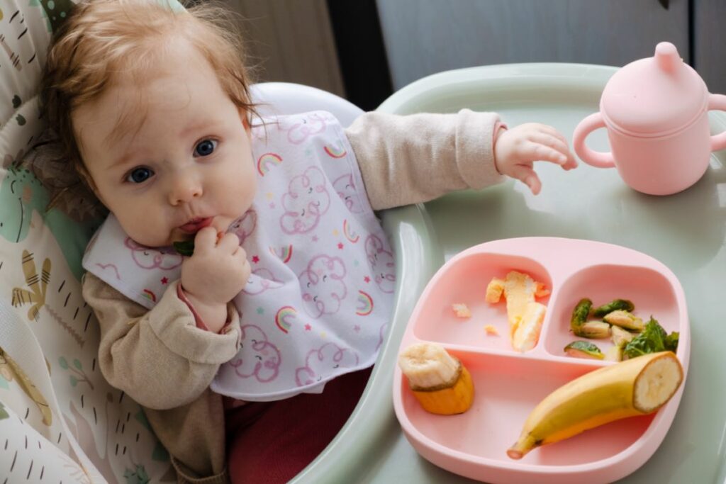 menina comendo frutas e verduras