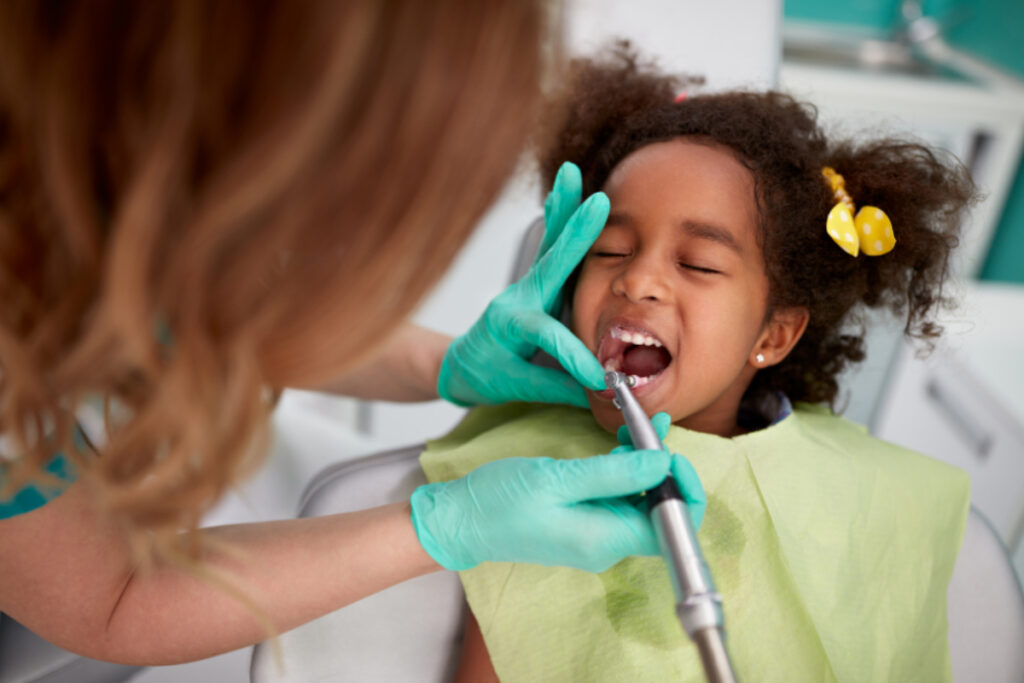 dentista cuidando dos dentes de uma criança