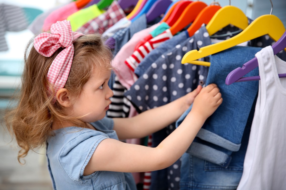 criança fazendo compras em loja de roupas