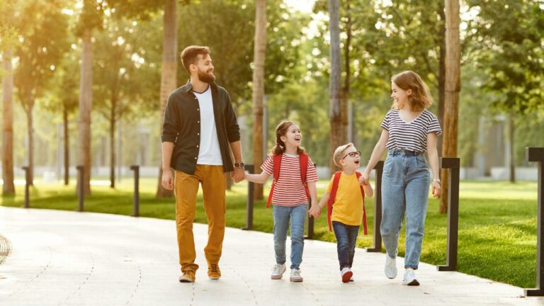 Família caminhando em parque.