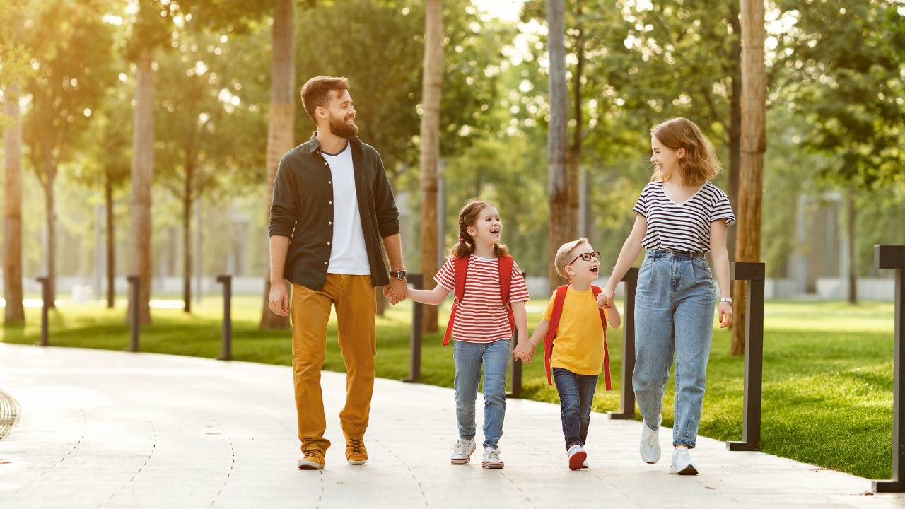 Família caminhando em parque.