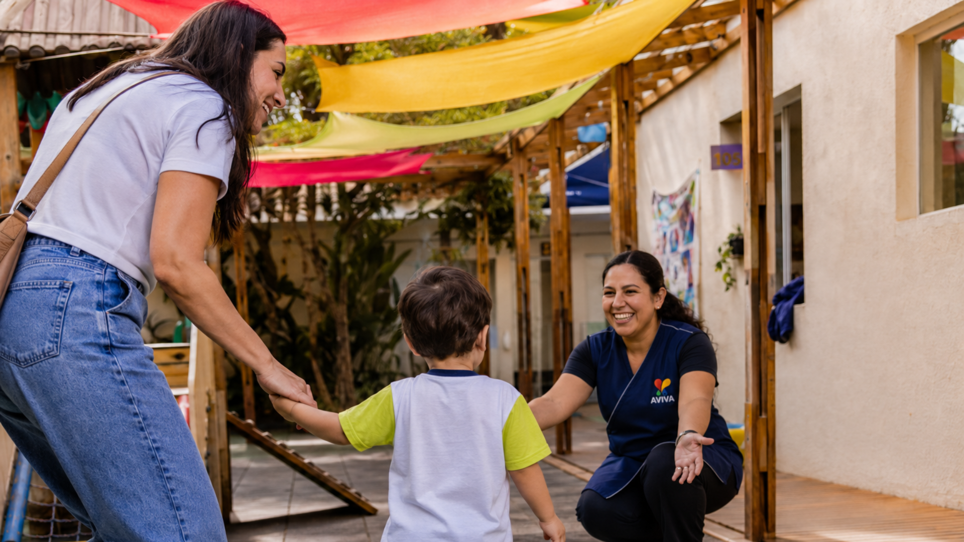 Criança é acolhida por professora na AVIVA durante o primeiro dia de adaptação escolar, em ambiente seguro, afetivo e preparado para a infância.