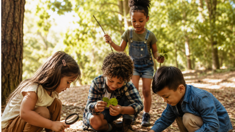 Crianças brincando ao ar livre em um ambiente natural, explorando folhas, galhos e elementos da natureza.
